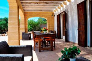 Villa con giardino e piscina privata 45 في مارينا دي بيسكولوس: فناء في الهواء الطلق مع طاولة وكراسي خشبية