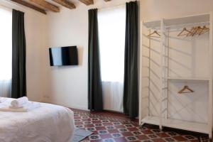 a bedroom with a bed and a tv on a wall at Traditional Italian House - Bergamo in Bergamo