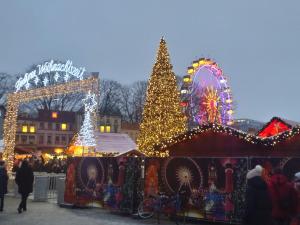 ein Weihnachtsmarkt mit einem Weihnachtsbaum und einem Riesenrad in der Unterkunft Mitte von Mitte - Blick auf den Turm in Berlin
