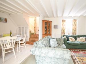 een woonkamer met een bank en een tafel bij Lyme Regis Cottage in Lyme Regis