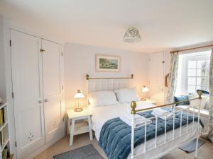een slaapkamer met een bed, een bureau, een bed en een raam bij Lyme Regis Cottage in Lyme Regis