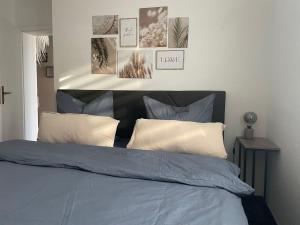 Schlafzimmer mit einem Bett mit Kissen und Bildern an der Wand in der Unterkunft Einliegerwohnung in Taunusstein Bleidenstadt in Taunusstein