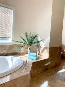 een badkamer met een bad en een potplant bij La Casa Lido in Lido Beach