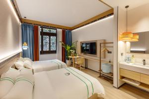 Habitación de hotel con 2 camas y lavamanos en Xishu Garden Inn, en Chengdú