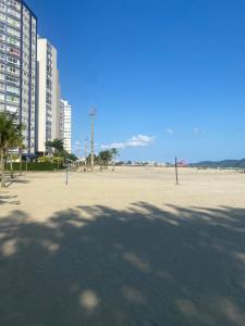 a large empty beach with buildings and palm trees at Apartamento Frente ao Mar Santos in Santos