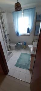 a bathroom with a sink and a toilet and a window at A casa di Sandra, costa dei Trabocchi in Paglieta
