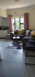 una sala de estar con sofás y una mesa. en Khanyisa Accommodation Services, en KwaDukuza