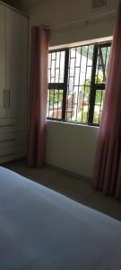 una stanza vuota con un letto e una finestra di Khanyisa Accommodation Services a KwaDukuza