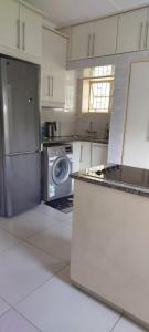 a kitchen with a stove and a washing machine at Khanyisa Accommodation Services in KwaDukuza +8 photos