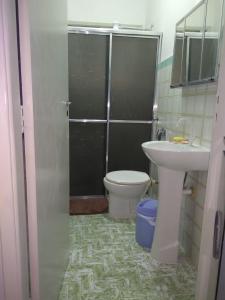 a bathroom with a shower and a toilet and a sink at Pé na areia in Mongaguá