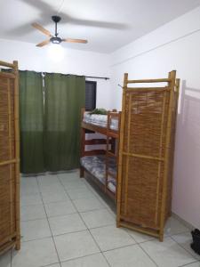 a room with bunk beds and a ceiling fan at Pé na areia in Mongaguá