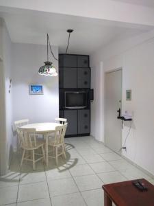 a kitchen with a table and chairs and a microwave at Pé na areia in Mongaguá
