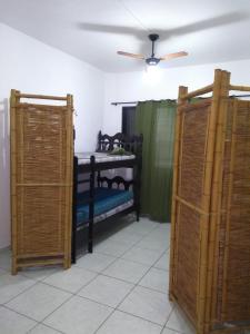 a room with two bunk beds and a ceiling at Pé na areia in Mongaguá