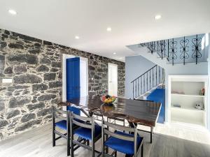 une salle à manger avec un mur en pierre, une table et des chaises dans l'établissement Casa da Horta by Atlantic Holiday, à Santa Cruz