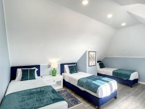 twee bedden in een kamer met blauw en wit bij Casa da Horta by Atlantic Holiday in Santa Cruz