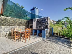 ein Glashaus mit einem Tisch und Stühlen auf einer Terrasse in der Unterkunft Casa da Horta by Atlantic Holiday in Santa Cruz