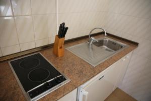 a kitchen counter with a sink and a knife block at Apartamentos Mar y Sal in La Savina