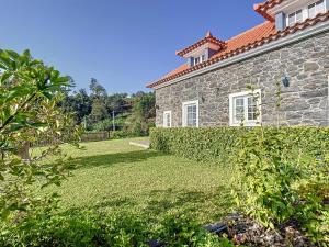 een stenen huis met een tuin ervoor bij Casa da Horta by Atlantic Holiday in Santa Cruz