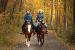 zwei Frauen reiten auf einem Waldweg in der Unterkunft Family Ranch Urlaub am Pferdehof in Frankenau