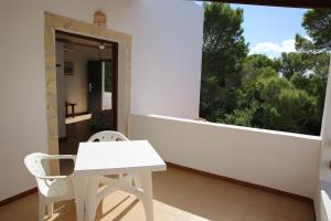 a white table and chair on a balcony with a window at Apartamentos Mar y Sal in La Savina