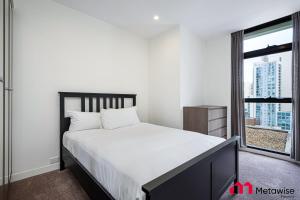 a bedroom with a large bed and a window at MetaWise Sydney CBD Haymarket Luxe 2Bed Penthouse Aqua in Sydney