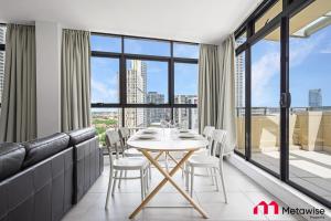 a dining room with a table and chairs at MetaWise Sydney CBD Haymarket Luxe 2Bed Penthouse Aqua in Sydney