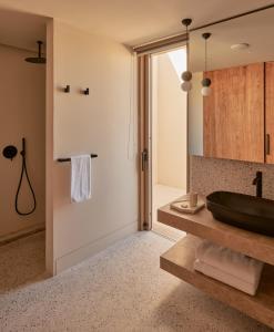 a bathroom with a black sink and a mirror at Noūs Santorini in Mesaria