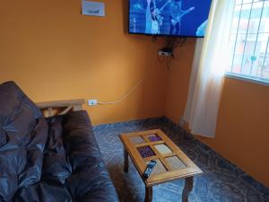 una sala de estar con un sofá y una mesa en Hospedaje Algo Nuestro, en Gobernador Gregores