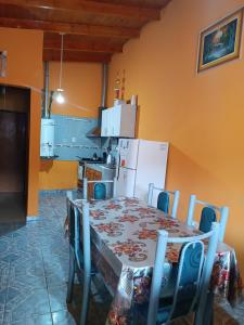 a kitchen with a table with chairs and a white refrigerator at Hospedaje Fliar En Gobernador Gregores in Gobernador Gregores