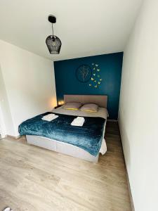 a bedroom with a bed with a blue wall at Disneyland Paris Familly Appart - 7 minutes Disney - Parking - Netflix - Wifi - BILLET DISNEY 80 euros in Chessy