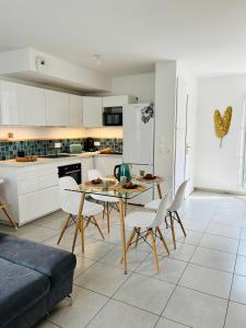 a kitchen and dining room with a table and chairs at Disneyland Paris Familly Appart - 7 minutes Disney - Parking - Netflix - Wifi - BILLET DISNEY 80 euros in Chessy