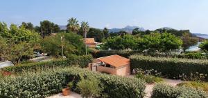 einen Garten mit Büschen und Bäumen und ein Gebäude in der Unterkunft Apartment Tiki Plage mit Meerblick und direkt am Strand in Saint-Raphaël