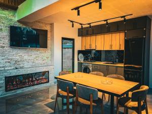 a dining room with a table and a fireplace at Qafqaz Royal Chalet in Gabala