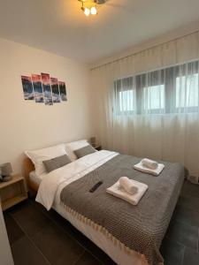 a bedroom with a bed with two towels on it at JOY APARTMENTS Zemun,Beograd in Zemun
