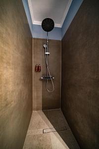 a bathroom with a shower with a fan on the wall at Hotel Cocó in Timişoara