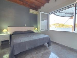 een slaapkamer met een bed en een groot raam bij Casa en el Centro con vistas - by Aloha Palma in Águilas