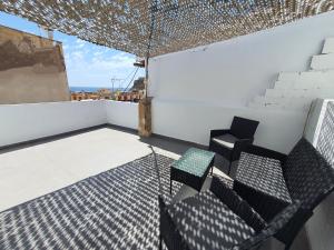 een balkon met 2 stoelen en een tafel bij Casa en el Centro con vistas - by Aloha Palma in Águilas