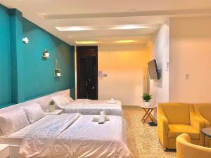 una habitación de hotel con 2 camas y una silla en Gia Khang en Dalat