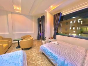 um quarto com uma cama, uma cadeira e uma janela em Gia Khang em Da Lat