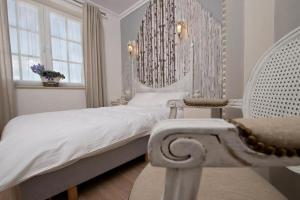a bedroom with a white bed and a chair at Miód Lawenda in Biardy