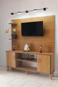 a wooden entertainment center with a television on a wall at Casa de Temporada em Gramado in Gramado
