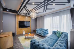 a living room with a blue couch and a tv at Luxury Home Affair in Oradea +23 photos