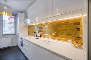 cocina con fregadero y pared de ladrillo amarillo en Luxury Home Affair, en Oradea