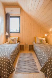 ein kleines Zimmer mit 2 Betten und einem Fenster in der Unterkunft Domki KREDKA in Jastarnia