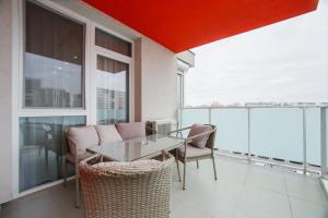 jadalnia ze stołem i krzesłami na balkonie w obiekcie Luxury Home Affair w mieście Oradea