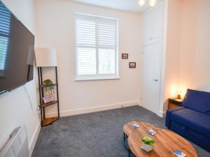 a living room with a blue couch and a table at Apartment 5 Victoria House in Lyme Regis