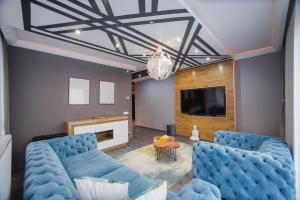 uma sala de estar com dois sofás azuis e uma televisão em Luxury Home Affair em Oradea