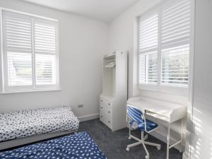 1 dormitorio con escritorio, 1 cama y ventanas en Apartment 5 Victoria House, en Lyme Regis