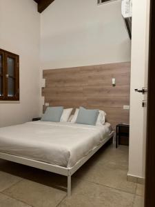 a bedroom with a large bed with a wooden headboard at Cottage in Center of Historic Zichron Yaakov in Zikhron Ya‘aqov