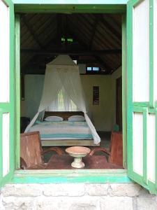 a bedroom with a bed with a table in a window at duegoal farmhouse in Jatiluwih